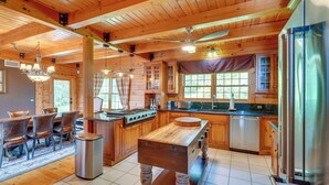 Una cocina amplia con armarios de madera, una isla central y electrodomésticos modernos.