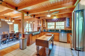 A spacious kitchen with wooden cabinets, a central island, and modern appliances. - Luxury Log Cabin w/ EV Charger & Mtn Views! (Blairstown)