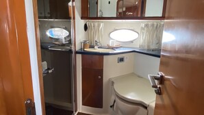 Un baño pequeño con inodoro, lavamanos y espejo.
