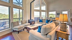 Un salón amplio con ventanas grandes, chimenea y una zona de estar acogedora.