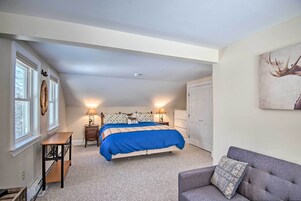 Un dormitorio con cama, mesitas de noche, escritorio, silla y armario.