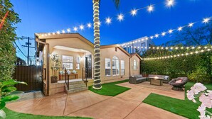 A house with a patio, outdoor furniture, and string lights.