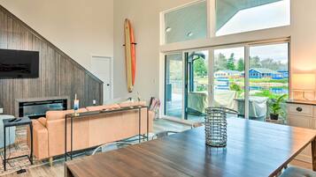 Een moderne woonkamer met een houten eettafel, een bank en een open haard.