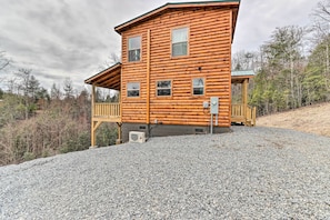 Une cabane en rondins avec un porche et une allée gravillonnée.