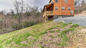 A wooden cabin with a balcony, surrounded by a forested hillside. - Cozy Mtn Cabin: Spacious Deck & Forest Views! (Murphy)
