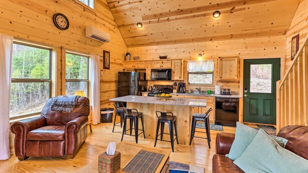 A cozy cabin interior with a wooden interior, a kitchen area, and a seating area with a fireplace. - Cozy Mtn Cabin: Spacious Deck & Forest Views! (Murphy)