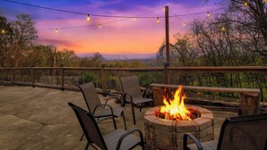An outdoor seating area with a fire pit and string lights against a sunset backdrop. - Hot Tub & Mini Golf: Mtn-view Haven in Kodak! (Kodak)