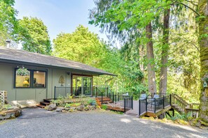 A house with a porch, steps, and a gravel driveway. - Riverfront Woodland Cabin: Wooded & Forested Views (Woodland)
