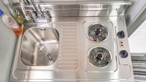 A stainless steel kitchen sink with two burners and a faucet.