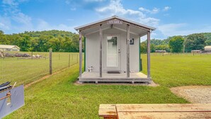 A small, single-room structure labeled "Yeti Cave 2" with a door and a small window, surrounded by a grassy field and a fence.