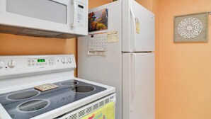 Eine Küche mit Herd, Mikrowelle und Kühlschrank.