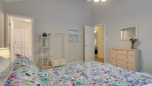 A bedroom with a bed, a dresser, a shelf unit, and a door leading to another room. - Pool, Trail Access! Dog-friendly Ocean Pines Haven (Berlin)