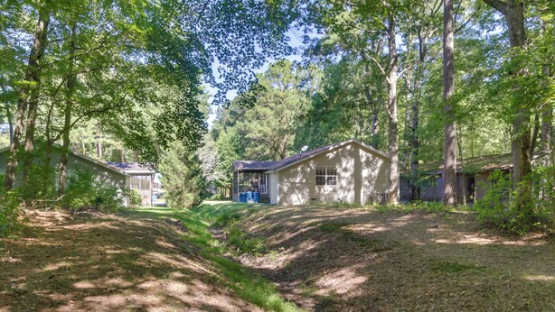 A secluded cabin area surrounded by dense trees, with two cabins and a small path leading through the forest. - Pool, Trail Access! Dog-friendly Ocean Pines Haven (Berlin)
