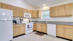A modern kitchen with wooden cabinets, a white refrigerator, a microwave, a stove, and a dishwasher. - Pool, Trail Access! Dog-friendly Ocean Pines Haven (Berlin)