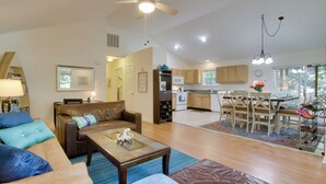 A spacious living room with a brown leather sofa, a glass coffee table, and a ceiling fan. - Pool, Trail Access! Dog-friendly Ocean Pines Haven (Berlin)