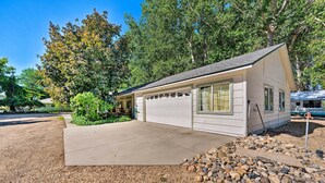 A single-story house with a garage, surrounded by a gravel driveway and a small rock garden. - Caldwell Country Home on Quiet Acreage (Caldwell)