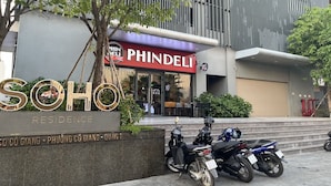 A building with a sign reading "PHINDELI" and "SOHO RESIDENCE" with motorcycles parked in front. - An Corner SOHO 3Bedrooms apt high floor nice view (Ho Chi Minh City)