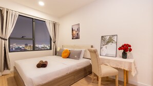 A neatly arranged bedroom with a bed, a chair, a small table, and a window with curtains. - An Corner SOHO 3Bedrooms apt high floor nice view (Ho Chi Minh City)