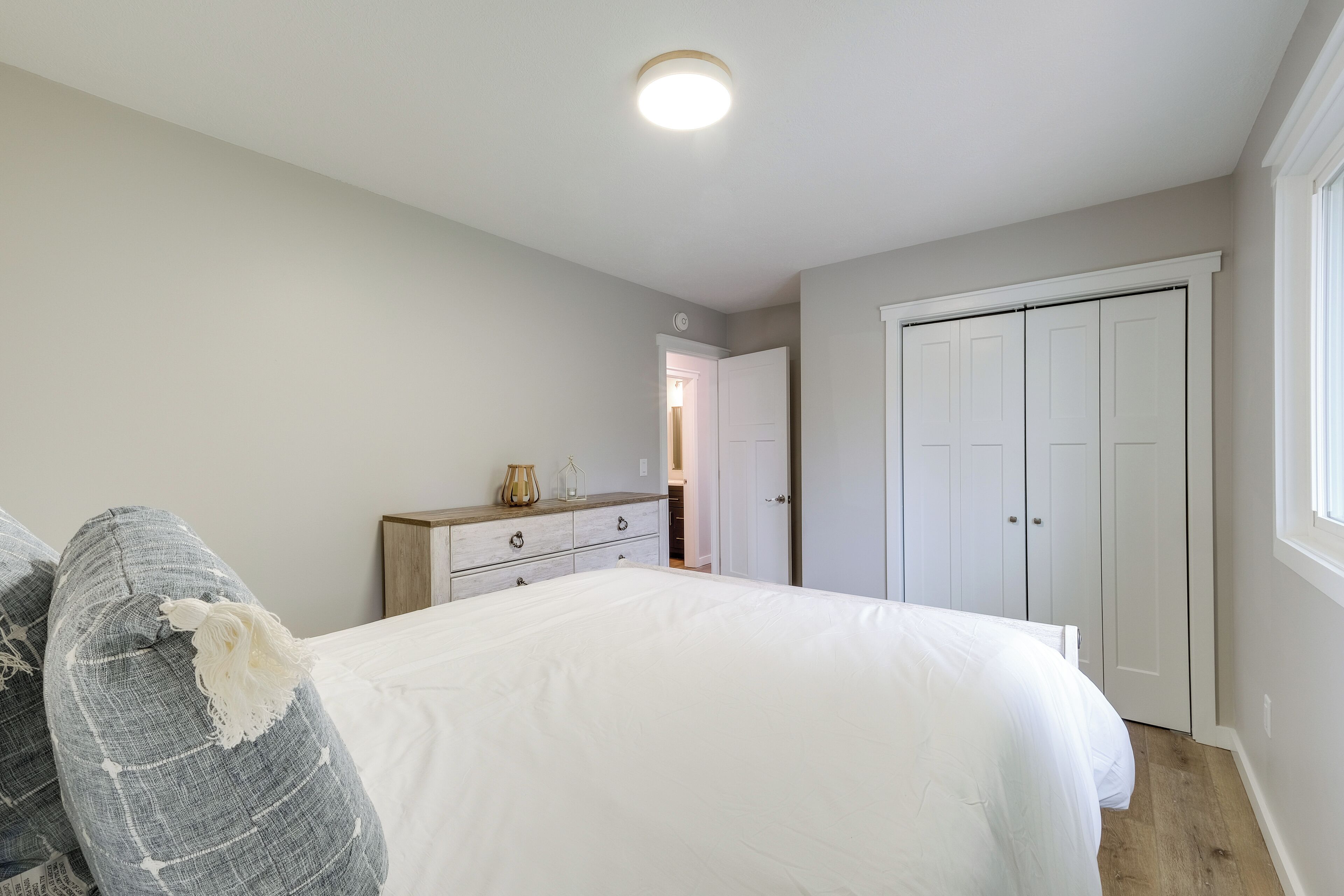 A bedroom with a bed, dresser, and closet.