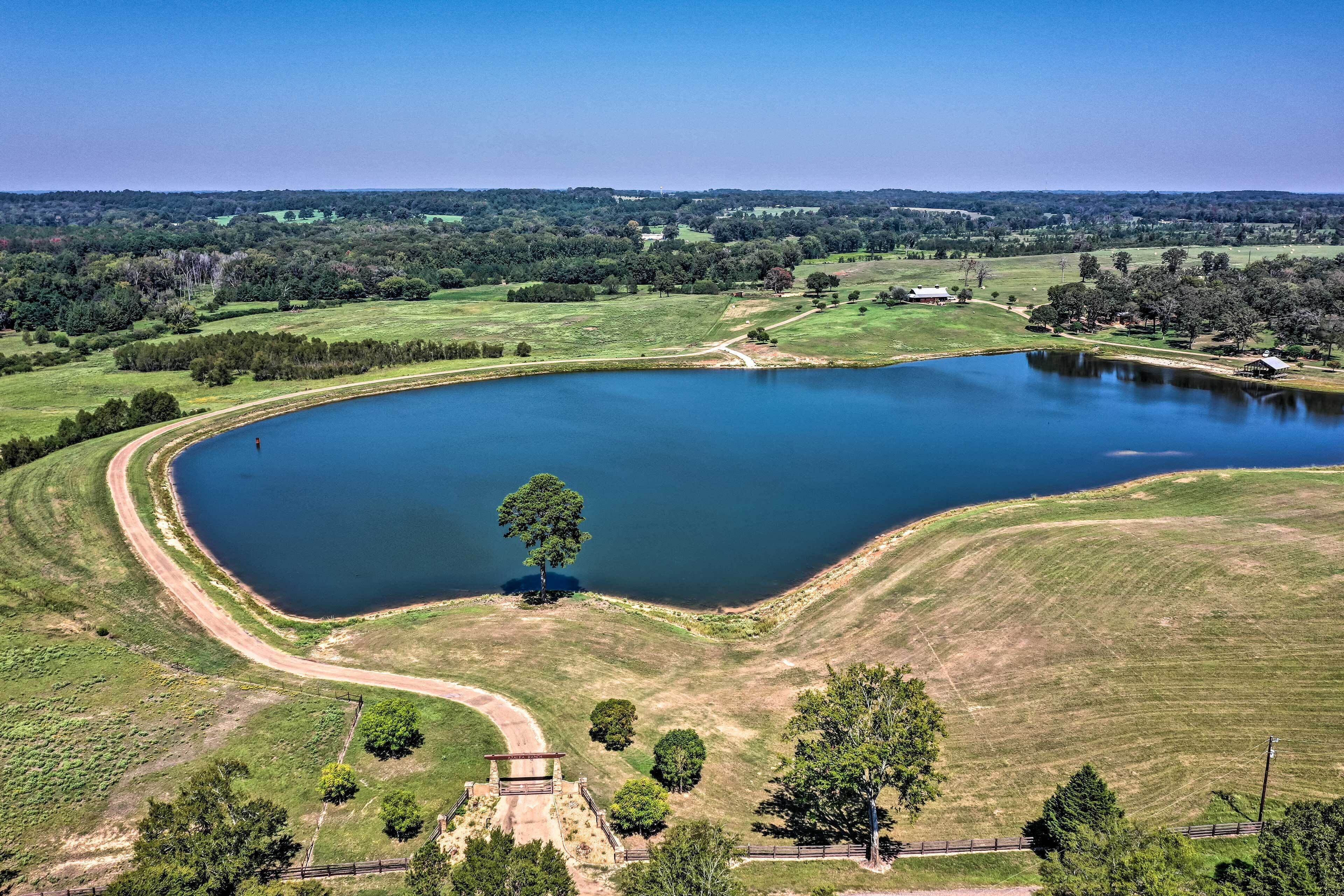 A large, oval-shaped lake surrounded by grassy fields and trees.
