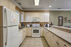 A kitchen with white cabinets, a refrigerator, a microwave, a stove, and a sink. - 3 Mi to Ocean: Resort Condo in Myrtle Beach! (Myrtle Beach)