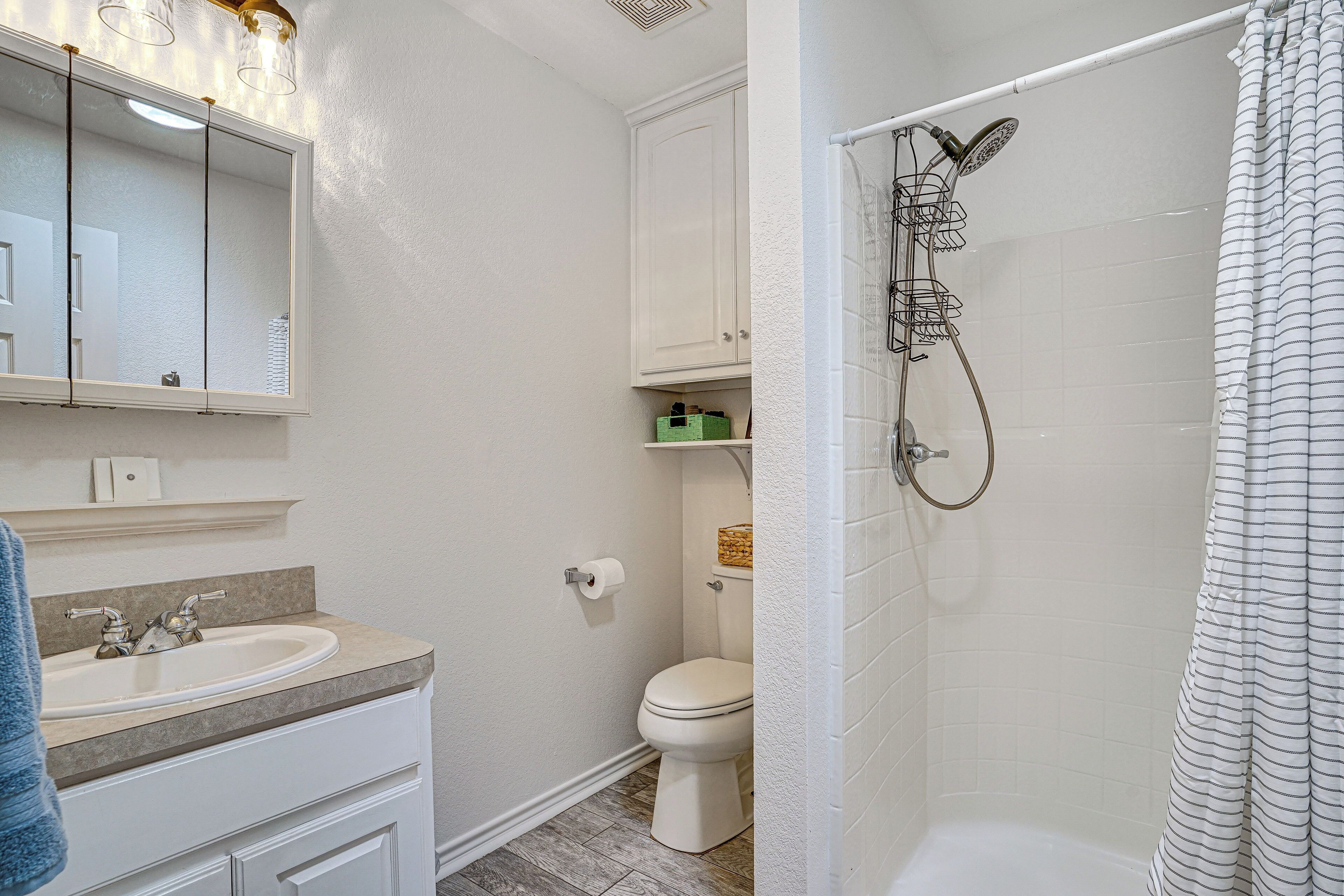 A bathroom with a sink, toilet, and shower.