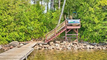 A wooden dock leading to a wooden platform with a sign reading "LYONS LAKESIDF".