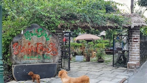 Un letrero de piedra con un perro y un golden retriever frente a una reja.