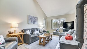 Un salon avec une cheminée, un canapé, une table basse et un téléviseur.