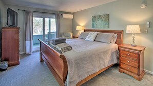 Une chambre à coucher avec un lit en bois, une table de chevet avec une lampe, une commode et une fenêtre avec des rideaux.