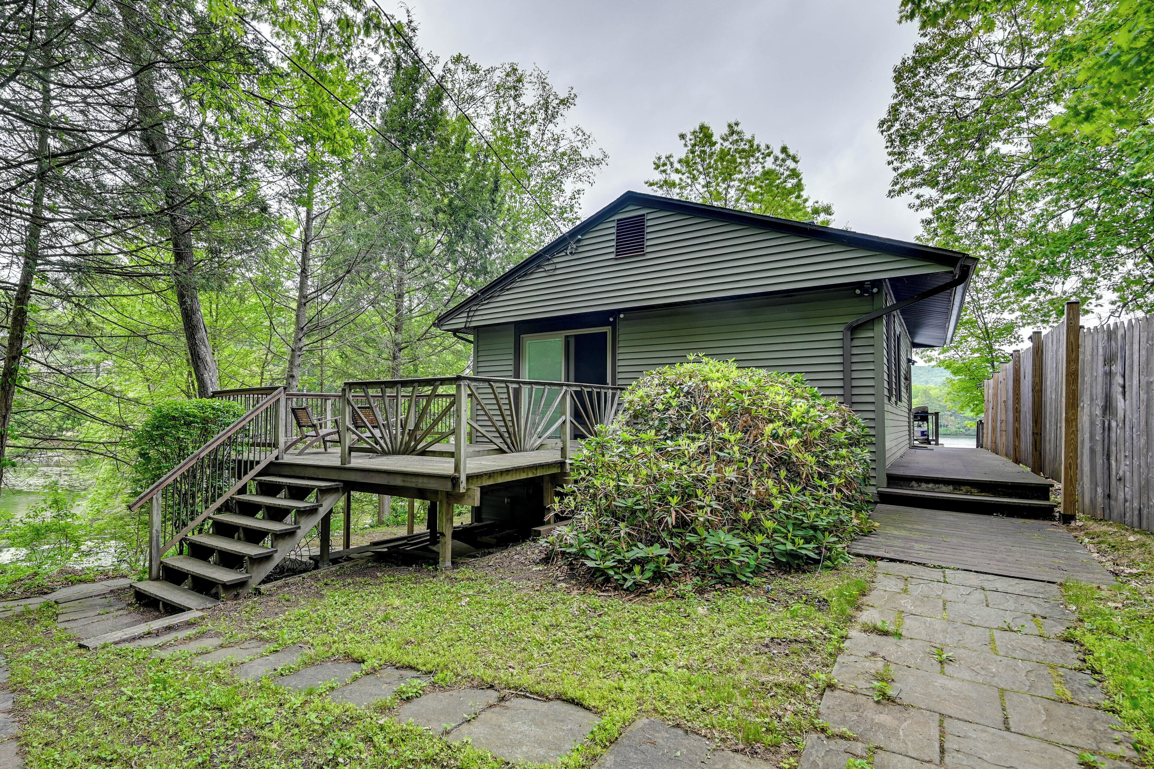 A small cabin with a wooden deck and stairs leading to the entrance.