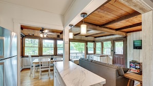 A spacious kitchen with a marble countertop, wooden ceiling beams, and large windows offering views of the outdoors. - Lakefront Granby Escape w/ Private Dock & Kayaks! (Granby)