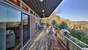 A wooden deck with outdoor furniture, a glass door entrance, and a view of the landscape. - Home With Wraparound Deck + Blue Ridge Mtn Views! (Radford)