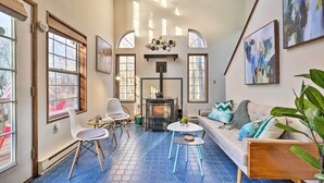 A cozy living room with a fireplace, a sofa, and a coffee table. - Modern Poconos Gem w/ Fire Pit, Deck & Pool Access (Tobyhanna)