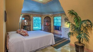 Un dormitorio con una cama, una planta en maceta y una ventana con vistas.