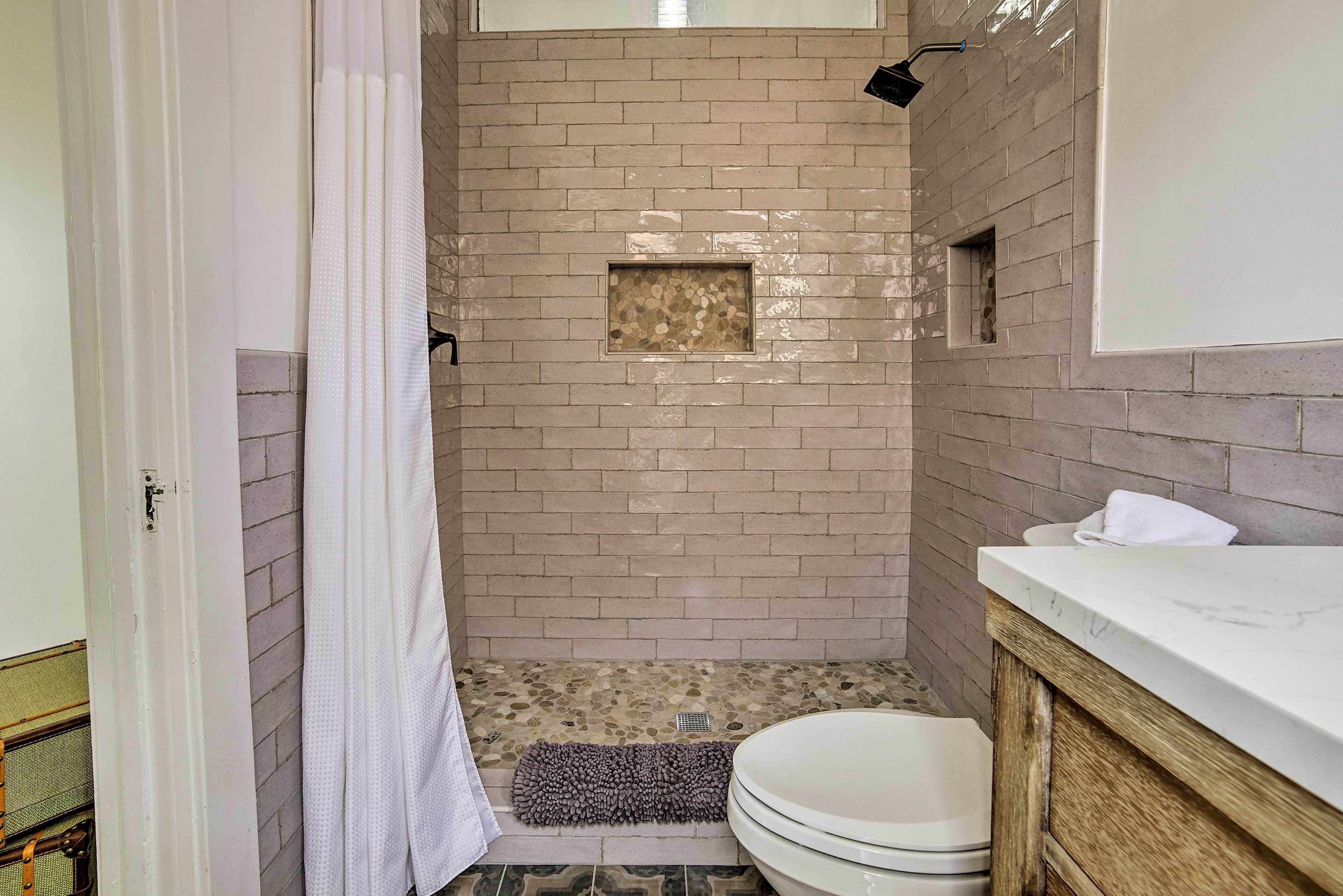 A bathroom with a shower, a toilet, and a sink.