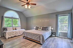 A bedroom with a bed, a bench, a ceiling fan, and a window with curtains. - Scotron Home W/game Room - 5 Miles to Skiing! (Scotrun)