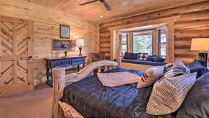 A log cabin bedroom with a bed, a desk, a chair, a window, and a ceiling fan. - Grand Mountain Retreat in Angel Fire w/ Game Room! (Eagle Nest)