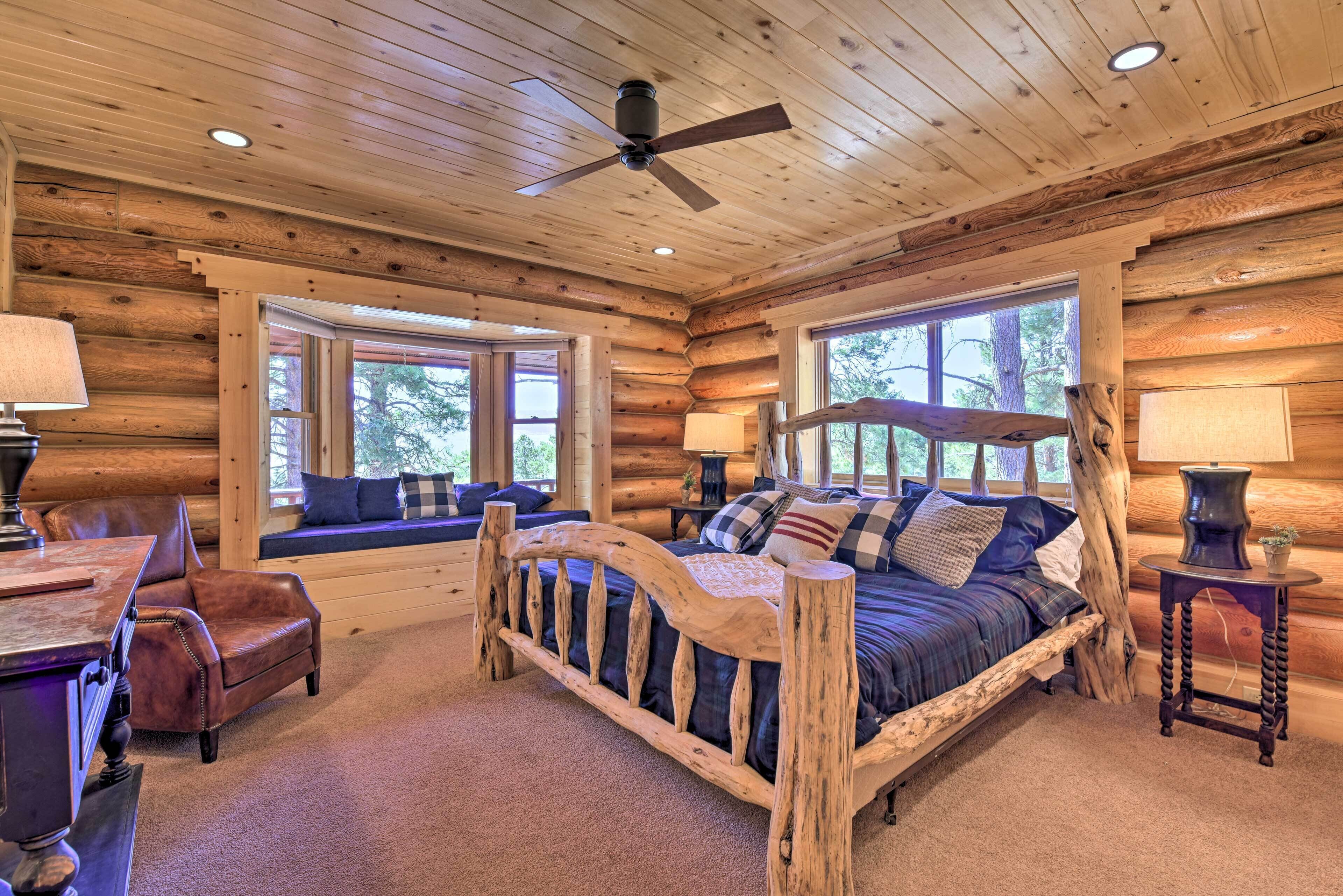 A log cabin bedroom with a wooden bed, a bench, and a desk.