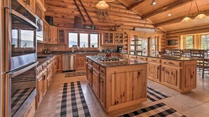 A spacious kitchen with wooden cabinets, stainless steel appliances, and a large island. - Grand Mountain Retreat in Angel Fire w/ Game Room! (Eagle Nest)