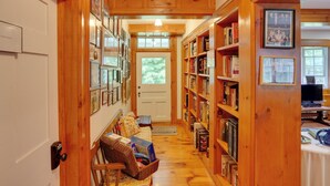 A wooden hallway with bookshelves, a door, and a bench. - Waterfalls and Trails at 'the Mills At Green Hole' (Hillsdale)