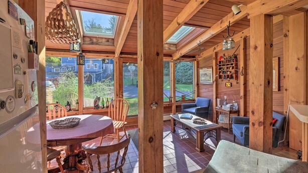 A wooden cabin with a dining area, a living room with a sofa and table, and a kitchen with a refrigerator and shelves. - Waterfalls and Trails at 'the Mills At Green Hole' (Hillsdale)