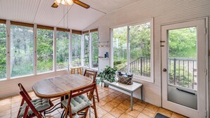 A sunroom with a wooden table and chairs, large windows, and a ceiling fan. - Breweries, Hiking Trails & Museums: Monument House (Monument)
