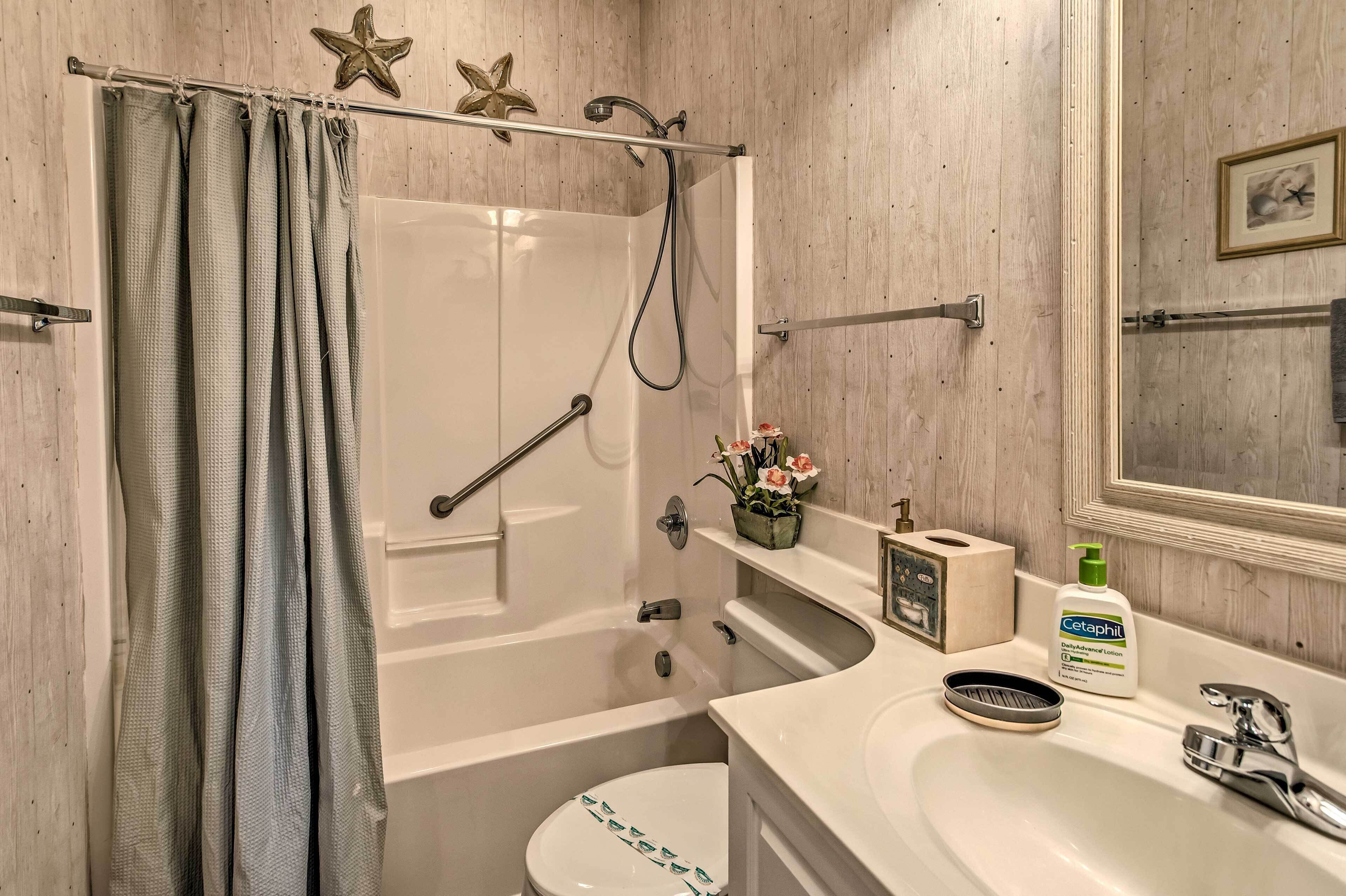 A bathroom with a bathtub, toilet, sink, and shower.