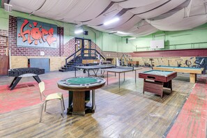Une salle de billard équipée d’une table de billard américain, d’une table de snooker et d’une table de poker.