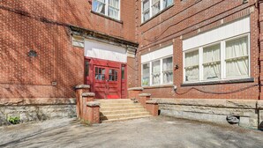 A red brick building with a red door, stone steps, and a stone wall. - Family ATV Adventure Hub! Renovated Rental in Gary (Gary)