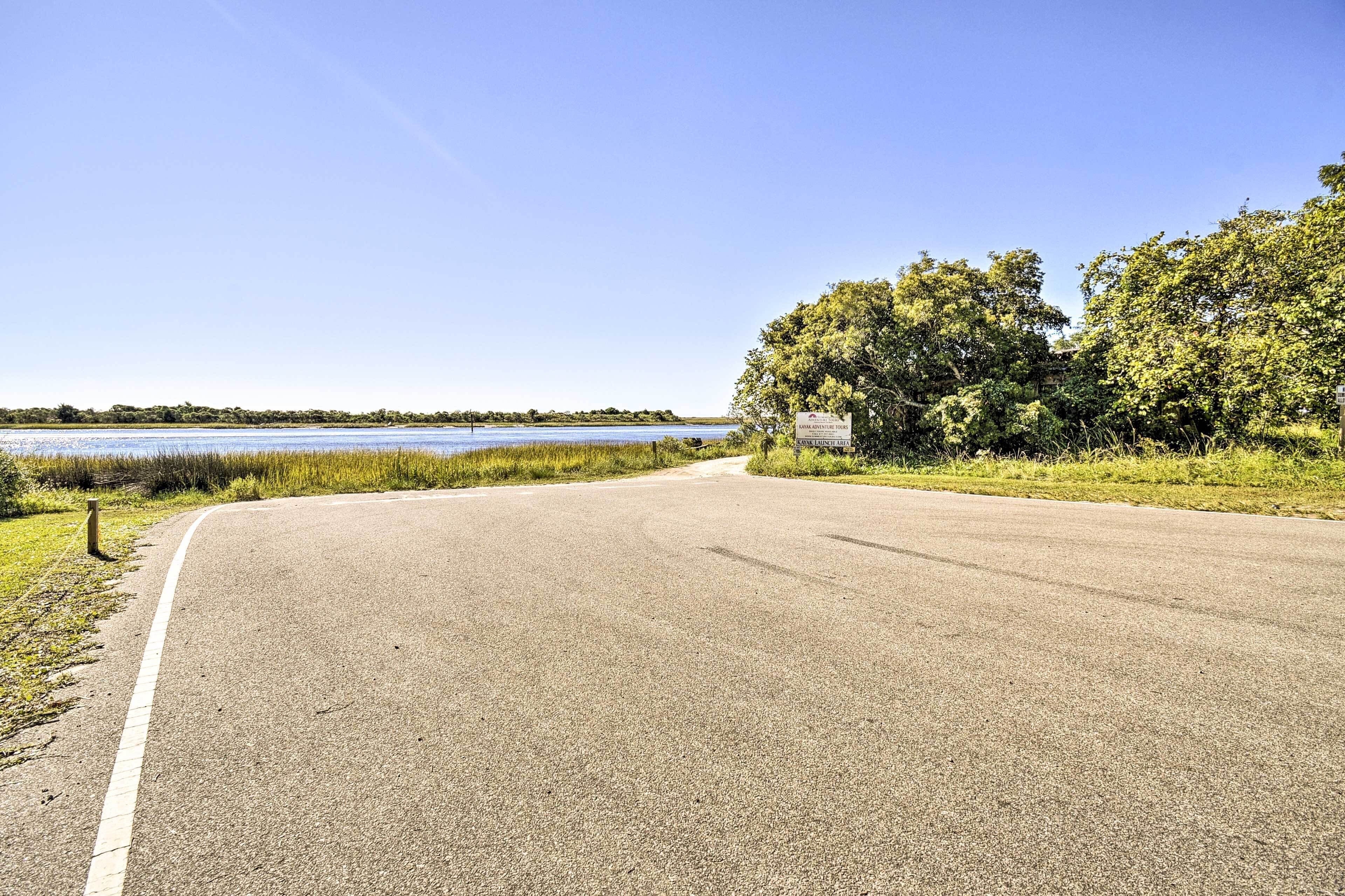 A paved road curving to the right with a signpost on the right side.