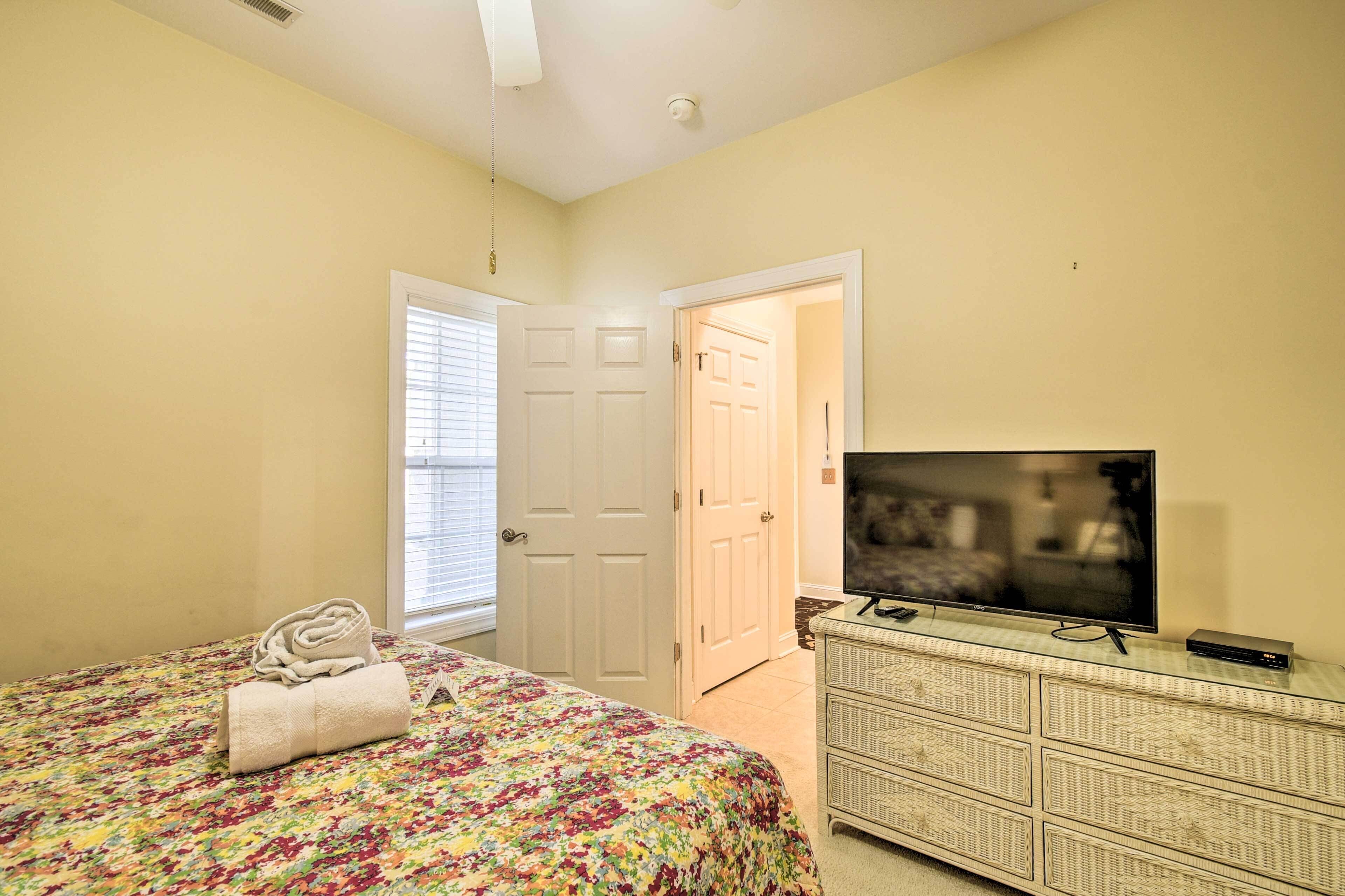 A bedroom with a bed, a television, and a dresser.