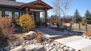 A building with a sign reading "Club Meadow Ridge" and a covered entrance area. - Condo w/ Balcony & Views - Steps to Ski Shuttle! (Fraser)