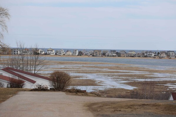 A coastal residential area with houses along the shoreline and a path leading to a white building with a red roof. - Wells Vacation Rental ~ 1 Mi to Beach Access! (Wells)